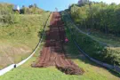 Machine smoothing out ski jump hillside